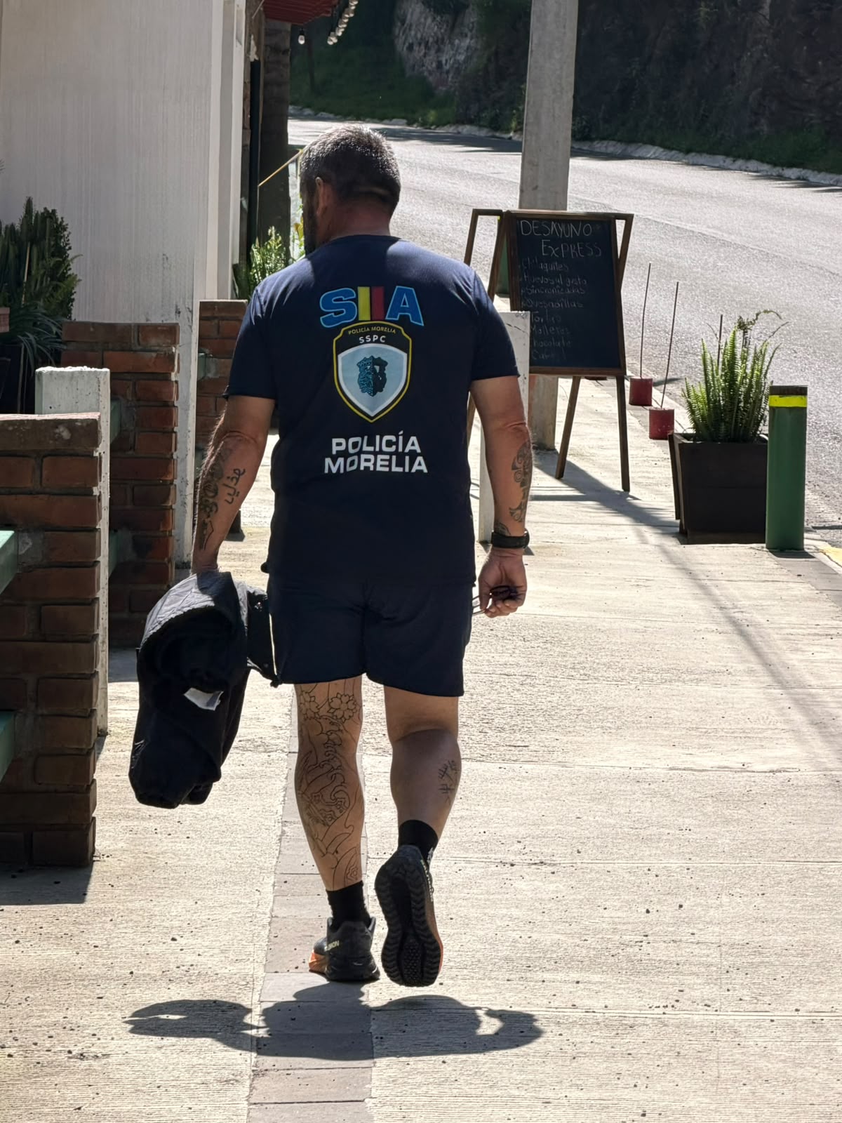 Igor avanzando de espaldas por una acera con camiseta de Policía Morelia