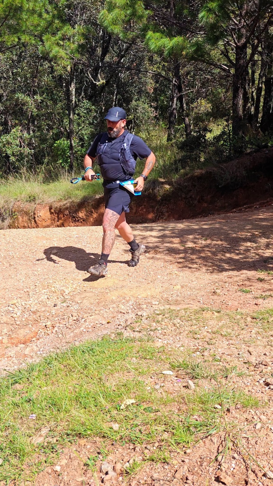 Igor corriendo por una pista de montaña entre pinos