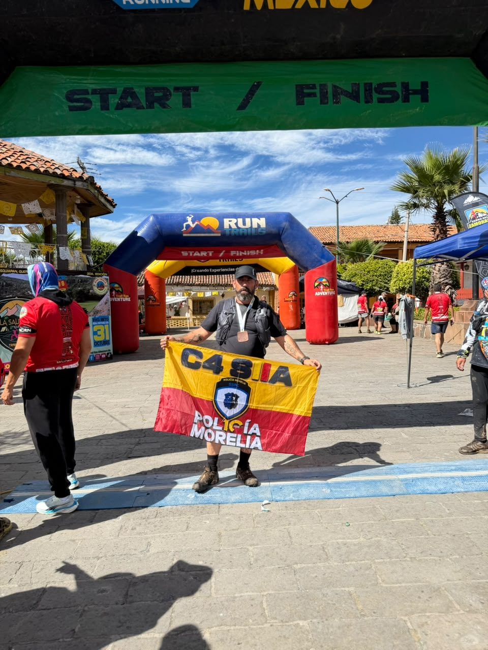 Igor en la meta con su medalla y la bandera de C4 SIIA Policía Morelia